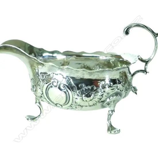 A small George III tripod silver sauceboat with shaped rim