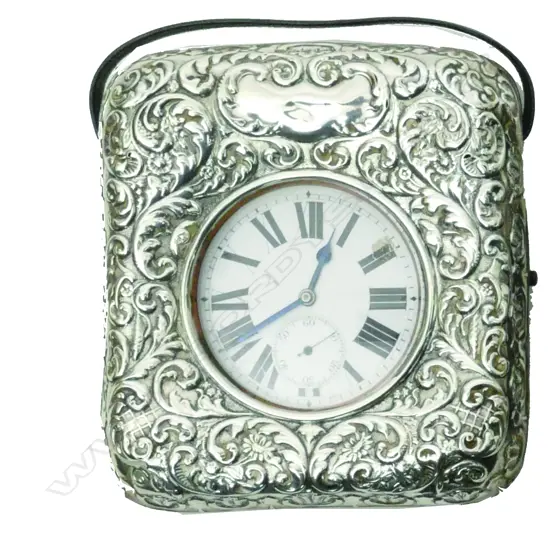 An Edwardian embossed silver covered pocket watch stand with watch