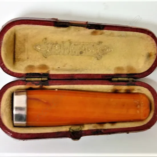 An early 20thC amber and silver cigarette holder