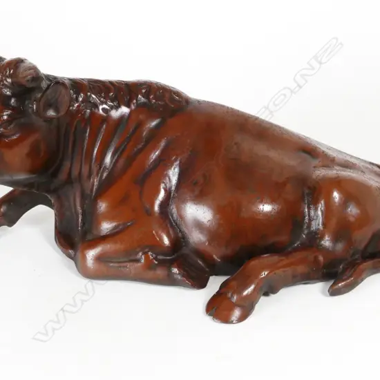 A cast iron model of a recumbent bull