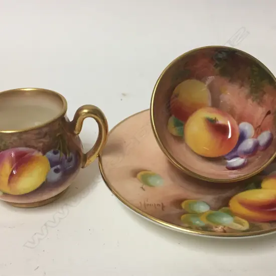 A Royal Worcester hand painted cup and saucer and miniature jug