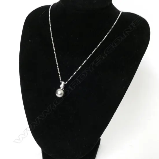 A 14ct. white gold black pearl and diamond pendant