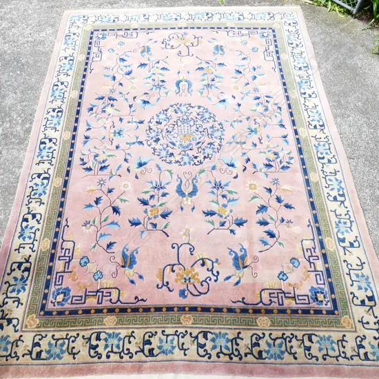 An old Chinese hand knotted wool carpet with circular medallion
