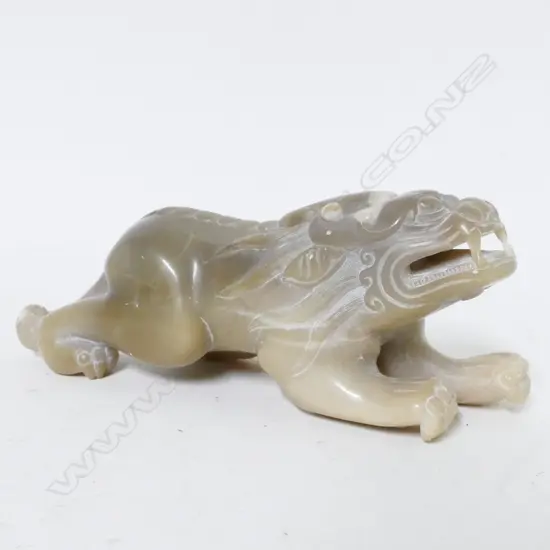 A pale caramel coloured jade carved temple dog