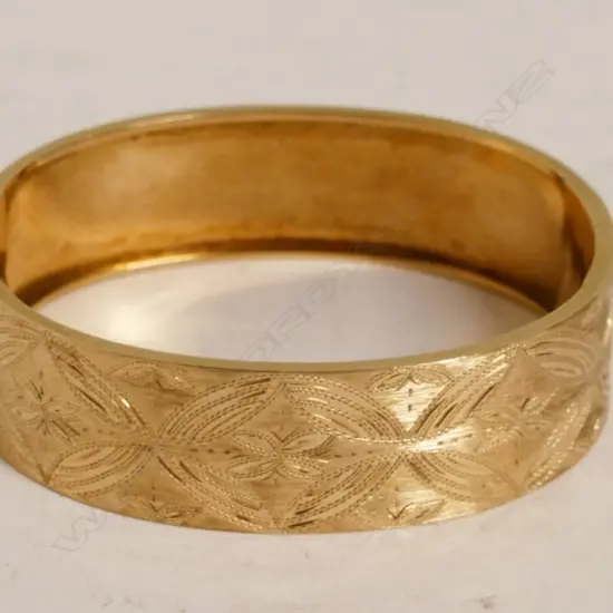 A 14ct. rose gold hinged bangle