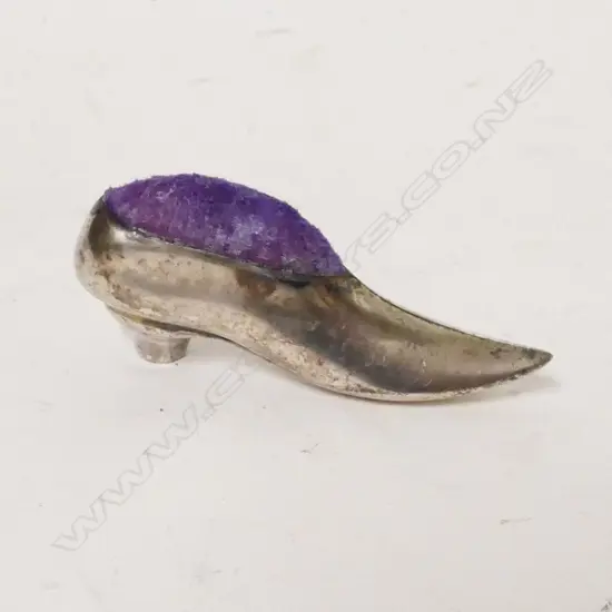 A silver shoe pin cushion