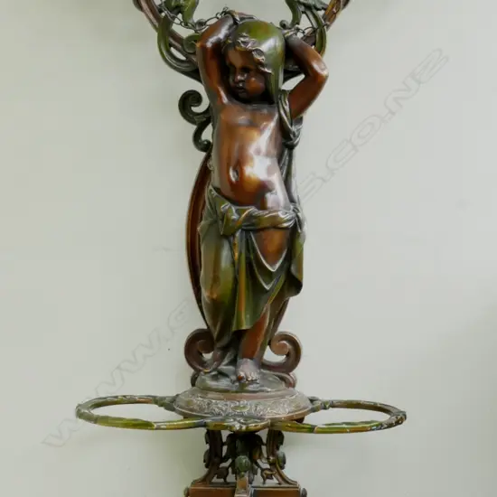 A large ornate cast iron hall stand with green and gold patina of French style