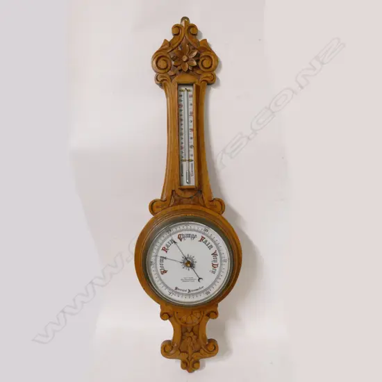 An Edwardian carved oak banjo wall aneroid barometer
