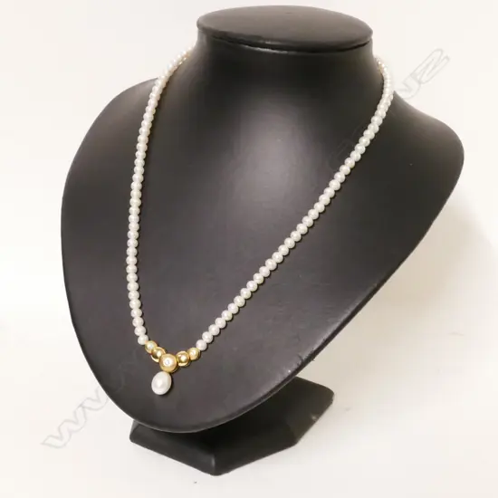 A cultured pearl necklace with 14ct. gold and diamond enhancer